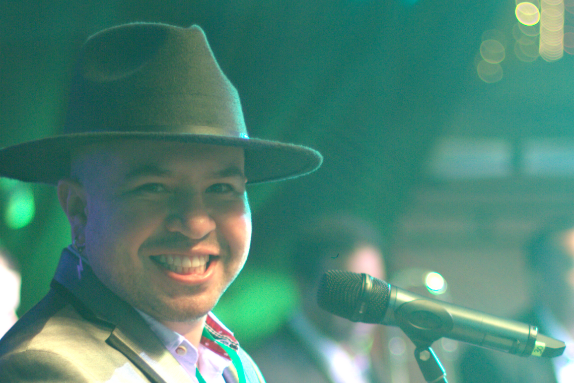 Fotografía de Mao Escobar sonriendo al lado de un micrófono 