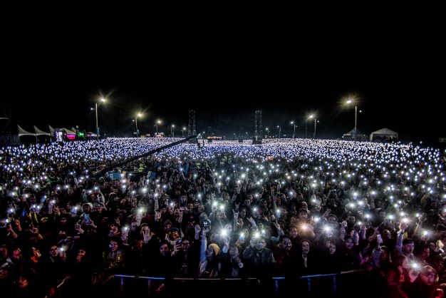 Miles de personas en el cierre de un festival al parque con luces encendidas