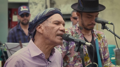 Fotografía de músico cantando con micrófono