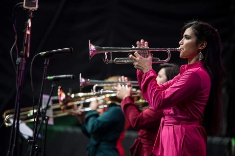 Fotografía de artista con una trompeta en escenario de salsa al parque